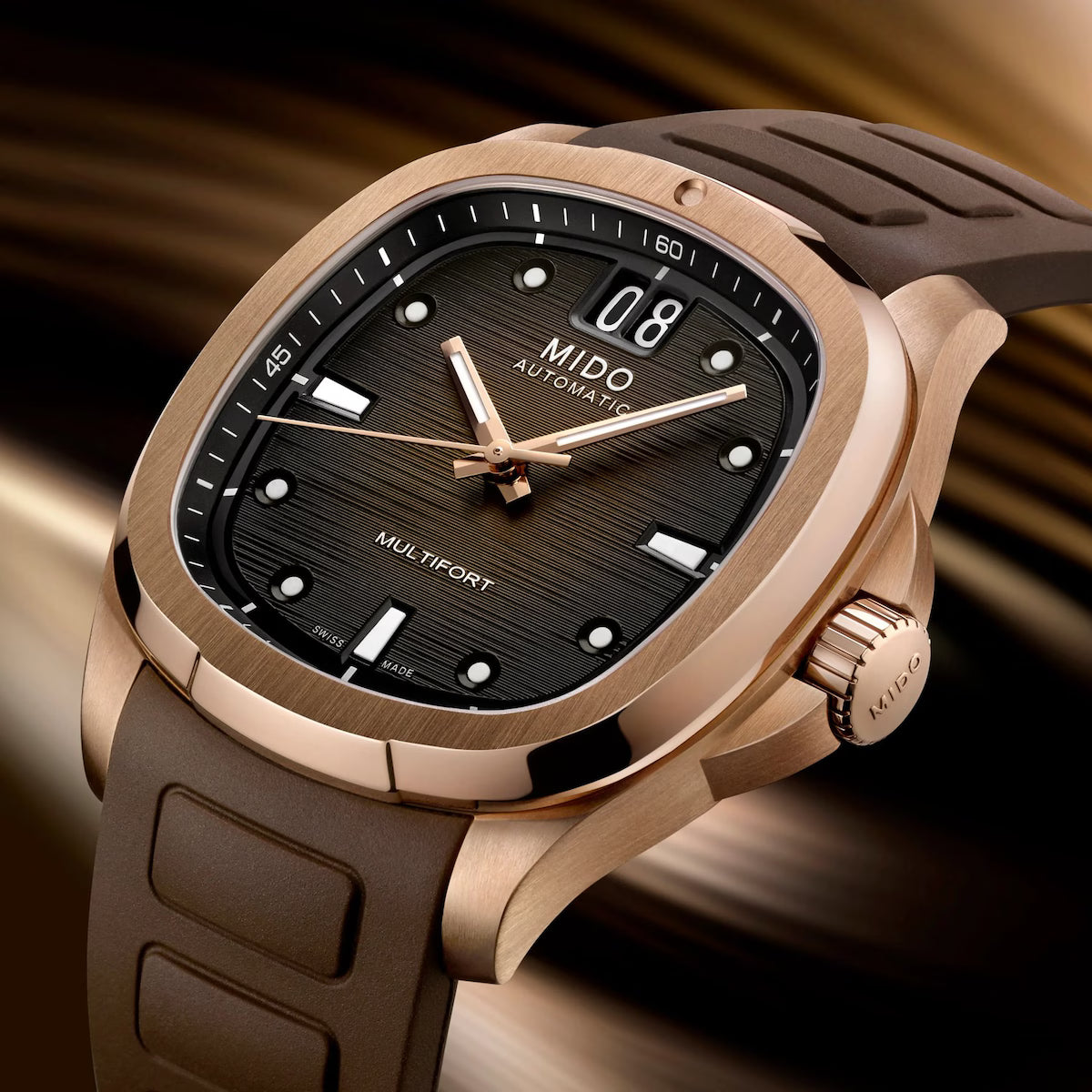 A close-up of the Mido Watches Multifort TV Big Date M0495263304100, showcasing a rose gold case, brown textured dial with bold hour markers, date display, and a brown rubber strap against a blurred golden background.