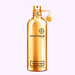 A gleaming gold Montale Perfumes MONTALE Aoud Leather EDP 100ml bottle with a matching stopper and tag stands elegantly against a soft pink background.