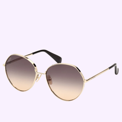 Showcased on a light purple background, the Max Mara Sunglasses MM0096 5732B (UPC 889214501776) feature round gold metal frames, brown gradient lenses, and black temple tips—an embodiment of Italian luxury from Max Mara Sunglasses for those in search of refined women’s designer eyewear.
