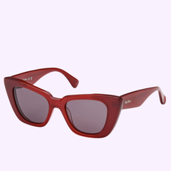 Max Mara Sunglasses MM0099 5066A UPC 889214516374 feature striking red cat-eye frames with thick construction and dark lenses, showcased against a light purple background. These chic women’s designer sunglasses from Max Mara embody the timeless elegance of Italian luxury eyewear, making them perfect for making a bold statement in any setting.