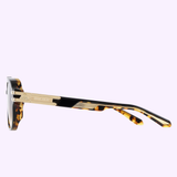 Side view of Maybach Optical THE HUSTLER I MG-AV-Z33 Sunglasses with gold detailing on the arms, branded logo, and gradient lens tint, set against a light purple background.