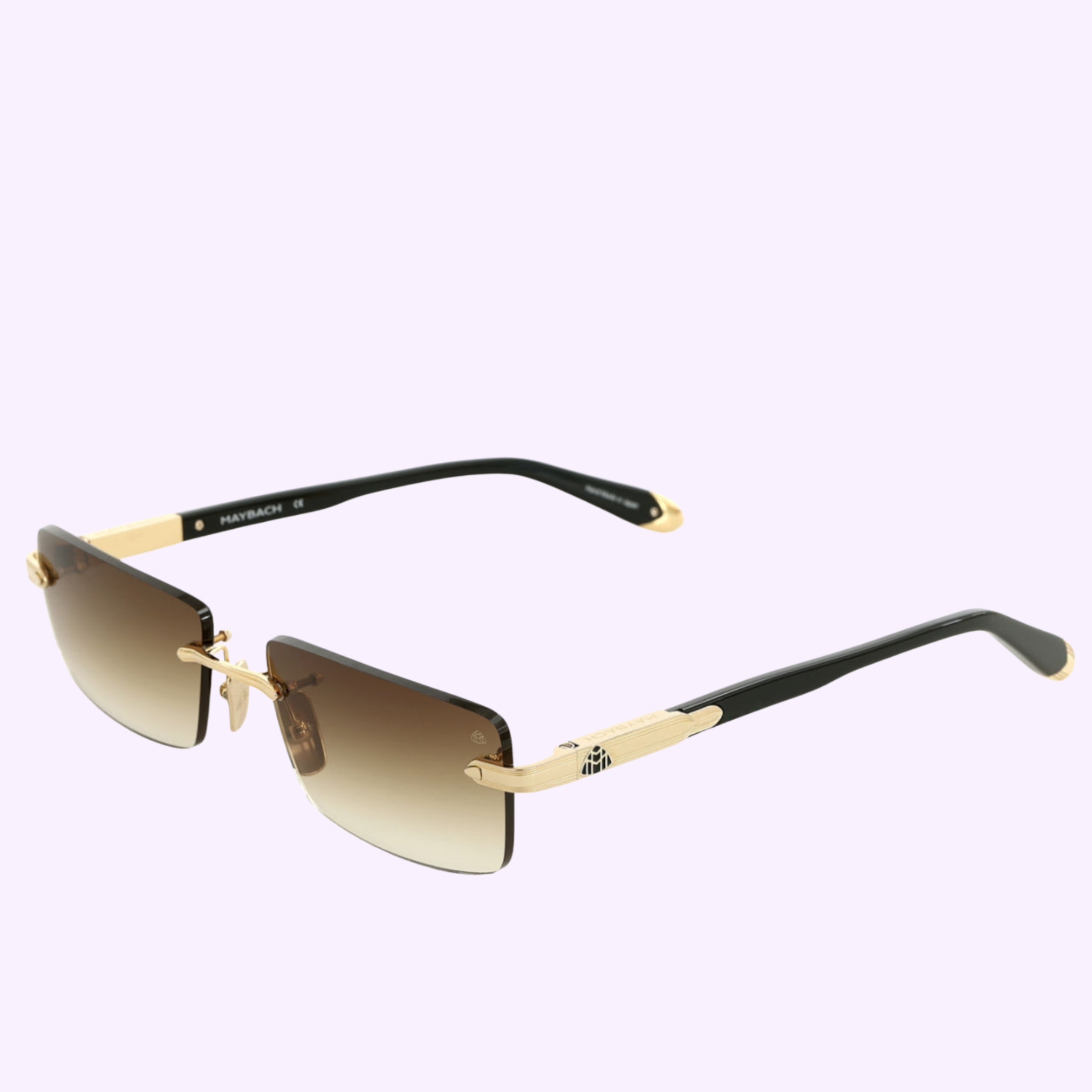 Gold and black rimless Maybach Optical Sunglasses, model THE SYMPHONY SUN I MG-ABM09, with brown gradient lenses, black arms, and gold accents, shown on a light purple background.