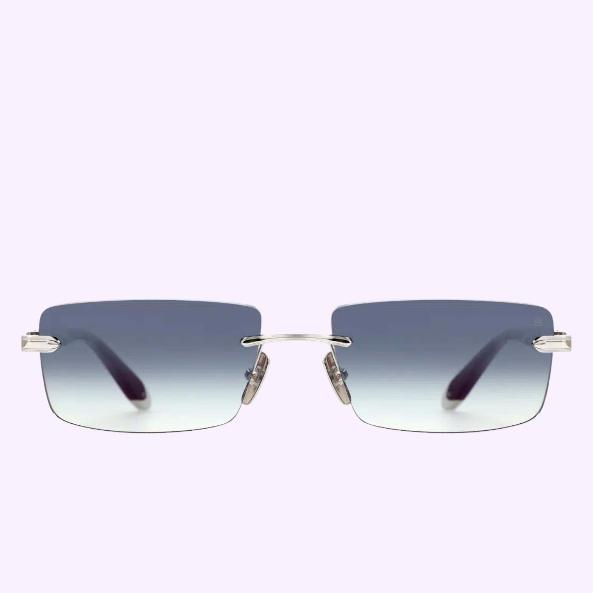 A pair of rimless rectangular sunglasses by Maybach Optical, inspired by the Maybach Sunglasses THE SYMPHONY SUN I PA-AASM12, featuring gradient blue to clear lenses, a silver bridge and arms, and black temple tips, displayed on a light purple background.