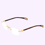 Maybach Optical Frames THE ARTIST IX G-AA-Z25 57-19-145 RX by Maybach Sunglasses feature rimless rectangular clear lenses, a platinum-plated titanium bridge and hinges, and dark tortoiseshell temple arms, shown on a light purple background.