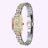 Showcasing the Michele Watches Deco Madison Mini MWW06D000178 by Michele Watches, this luxurious wristwatch features a striking gold and silver metal band, a square gold-tone face adorned with diamond accents, elegant Roman numerals, and a signature red gem on the crown. Set against a light purple background, this exquisite timepiece embodies sophistication and timeless charm.