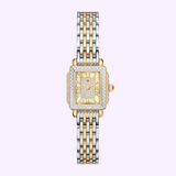 Experience the timeless elegance of the Michele Watches Deco Madison Mini MWW06D000178—a luxurious wristwatch featuring a rectangular gold and diamond-studded face with gold Roman numerals, complemented by a two-tone silver and gold metal link band, beautifully set against a light purple background.