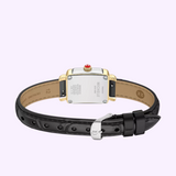 The Michele Watches Deco Madison Mini MWW06D000179, featuring a black leather strap, silver case back, gold accents, and a striking red crown, is elegantly showcased from the back against a light purple background.