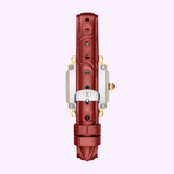 The Michele Watches Deco Madison Mini MWW06D000181 features a ruby red leather strap, a gold and silver case, and is displayed from the back to reveal its silver buckle and decorative crown, set against a light purple background—an elegant timepiece that perfectly captures the signature style of Michele Watches.
