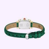 A Michele Watches Deco Madison Mini MWW06D000182 wristwatch by Michele Watches, featuring a green leather band, silver buckle, and a rectangular gold-trimmed case, is shown from the back to highlight its engraved details and signature red crown.