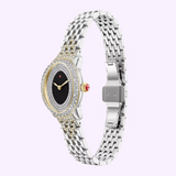 A luxurious Michele Watches Serein Oval Diamond MWW21H000005 timepiece by Michele Watches, this stunning 18K gold-plated watch features a silver and gold metal band, an oval black face adorned with diamond accents around the bezel, and a distinctive red crown on the side. Displayed elegantly on a light purple background, it showcases precise Swiss movement and exudes timeless sophistication.