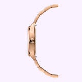 A rose-gold-coloured PVD wristwatch, the Mido Multifort TV 28 Quartz M0491103329600 by Mido Watches, is displayed in profile against a light background, emphasizing its slim case and crown. This elegant timepiece beautifully combines contemporary design with timeless appeal.