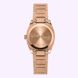 A rose gold PVD wristwatch from Mido Watches is pictured from the back, revealing the engraved Mido logo along with markings for water resistance, stainless steel, and sapphire crystal. The watch features a metal link band and is part of the elegant Multifort TV 28 Quartz M0491103329600 collection.