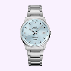 The Mido Watches Commander Lady M0212071104100 is a Swiss automatic watch with a metallic bracelet, light blue dial, silver hour markers, three hands, and a date window at 3 o’clock.