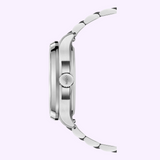 Side view of a silver metal Mido Watches Multifort TV Big Date Alebrijes M0495261108102 with round case, link bracelet, visible crown, and brushed finish. Background is light pastel purple.