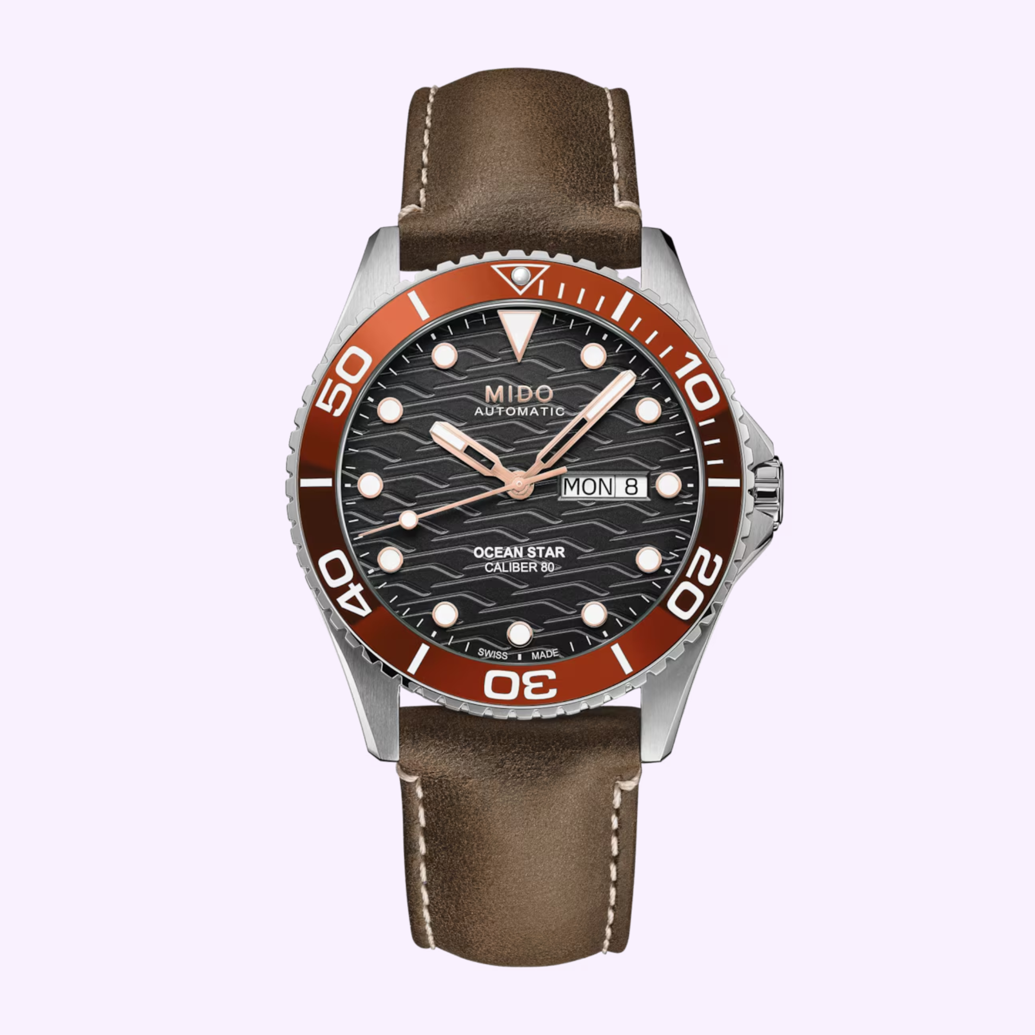 The Mido Watches Ocean Star 200C M0424301605100 is a Swiss diving watch with a brown leather strap, round silver case, black textured dial, brown bezel with white numbers, silver hour markers, and a day-date display.