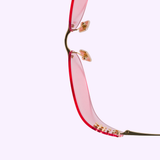 A close-up of the upper half of Miu Miu Sunglasses 0MU A51S 5AK90Y75, featuring a red, rimless design with gold nose pads and arms, set against a pale lavender background to highlight the elegance of Miu Miu Sunglasses.