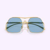 The Miu Miu Sunglasses 0MU A55S 5AK30U57, featuring gold aviator frames and blue-tinted lenses, are displayed on a light lavender background, facing the viewer directly.
