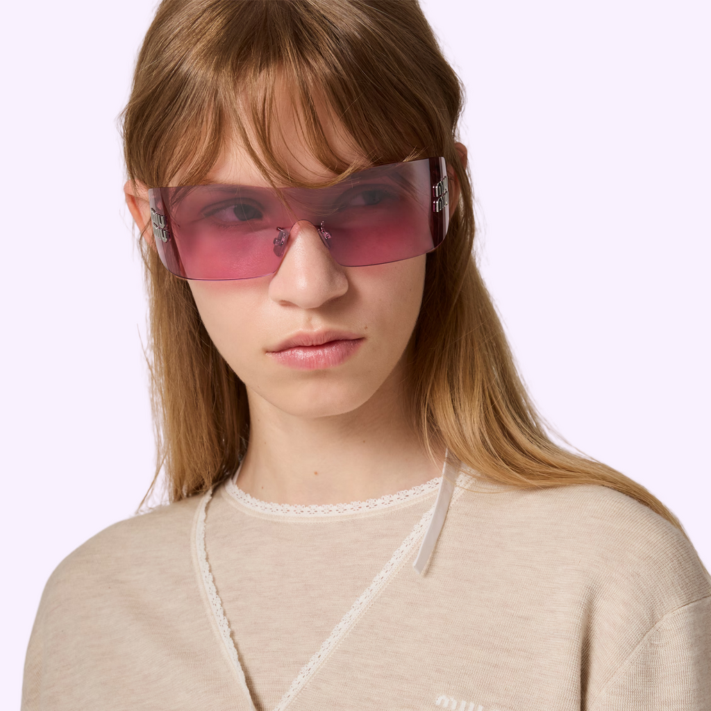 Model wearing Miu Miu 0MU B53S sunglasses with pink lenses and silver temples