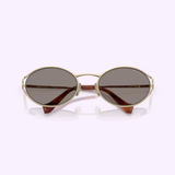 The Miu Miu sunglasses 0MU 52YS ZVN80Q54 by Miu Miu Sunglasses showcase an oval-shaped design with gold frames and brown tinted lenses, presented facing forward on a light purple background.