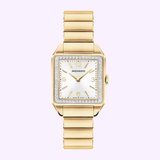 The Movado Watches 3650250 Heritage 1917 features an Art Deco-inspired face, diamond-studded bezel, gold hour markers, and gold link bracelet, displayed on a light purple background.