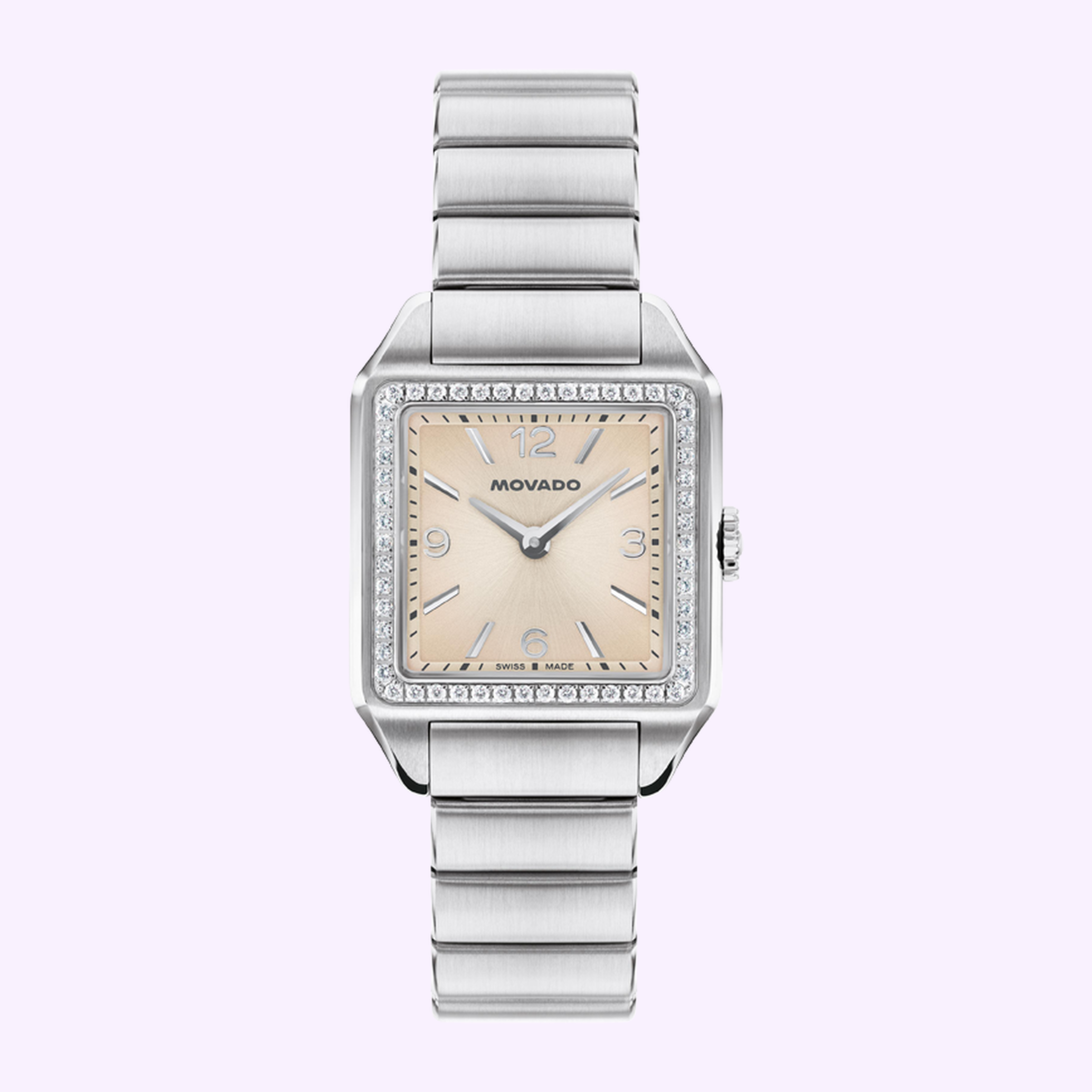 The Movado Watches 3650251 Heritage 1917 features a square face, silver metal band, light pink dial, silver markers and hands, and an Art Deco bezel with clear stones, displayed on a light purple background.