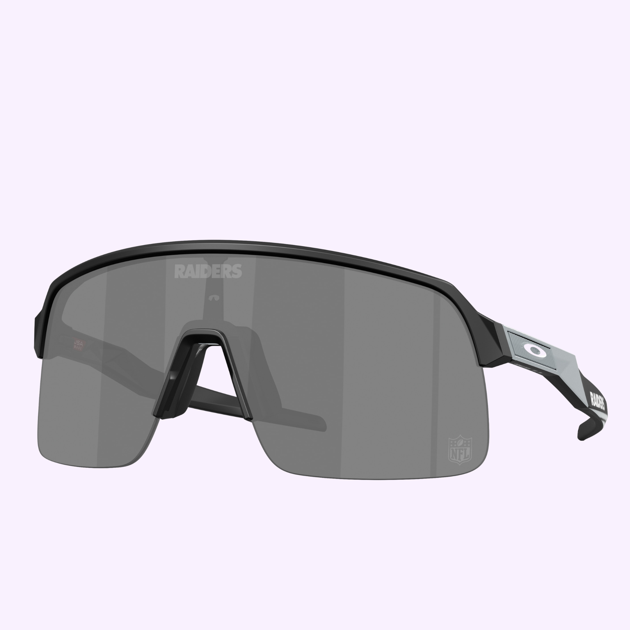 Oakley Sunglasses 0OO9463 94639939 in black with a large gray lens, RAIDERS and NFL logos, plus Oakley branding on the arms, displayed on a light purple background—ideal for sports fans and tech-savvy users.