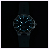Oris Watches Aquis Date divers watch with glowing blue indices and hands on a dark black dial and rubber strap.