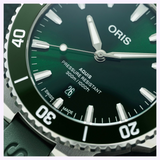 Close-up of a green dial Oris Watches Aquis Date featuring luminous silver hands, index markers, a date window displaying the number 26, and a rotating bezel with white numerals.
