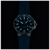 Oris Watches Aquis Date diving watch with a dark rubber strap and a glowing blue luminous dial face set against a black background.