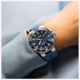 An Oris Watches Aquis Date with a blue dial and matching rubber strap worn on a wrist, exemplifying Swiss watchmaking.