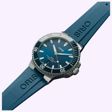 Blue Oris Watches Aquis Date diver’s watch with a matching rubber strap, featuring a dark blue dial with luminous hands and a rotating bezel.
