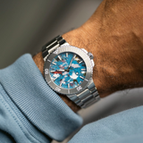 Oris Watches Aquis Date Upcycle Calibre 400 wristwatch with a metal link bracelet and a dial featuring a multicolored, marbled pattern of blue, white, and red pieces.