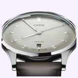 Oris Watches Artelier Date featuring a silver-toned case, textured light gray dial with thin markers and central hands, a date window at six o’clock, and a dark brown leather strap.