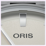 Close-up of an Oris Watches Artelier Date watch dial featuring a textured off-white face, silver hour markers, and the word ORIS printed in black.