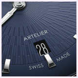 Close-up of a blue Oris Watches Artelier Date dial with a textured radial pattern, a date window displaying 28, and the text ARTELIER and SWISS MADE.