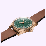 Oris Watches Big Crown Pointer Date 80th Anniversary Edition bronze watch featuring an aviation-inspired green dial, white numerals, a date indicator hand, and a brown leather strap.