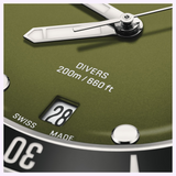 Close-up of a dark olive green Oris Watches Divers Date watch face with white hands, a date window displaying 28, and text reading DIVERS 200m / 660 ft and SWISS MADE.
