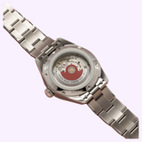 Stainless steel Oris Watches Divers Date watch with a link bracelet, viewed from the back to reveal the mechanical movement and a signature red rotor through a clear case back.