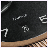 Close-up of an Oris Watches ProPilot Bronze watch face with a black textured dial, white numerals, and a date display showing the number 28, set within a bronze case.