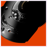 Close-up of interlocking metal gears inside an Oris Watches ProPilot Date mechanical watch movement against an orange background.