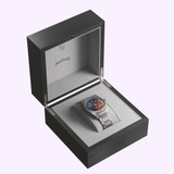 An Oris Watches ProPilot X Gonzo Edition titanium wristwatch with a multi-colored skeleton dial resting inside an open, dark wooden presentation box featuring Muppets branding on the interior lid.