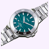 Oris Watches Yangtze Jiangtun Limited Edition watch with a metallic silver link bracelet and a teal dial featuring a subtle wavy pattern, silver indices, and a date display at the six o’clock position.