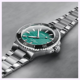 An Oris Watches Yangtze Jiangtun Limited Edition watch with a silver-tone metal bracelet, a black rotating bezel, and a gradient green dial featuring a wave pattern and a date window at the six o’clock position.