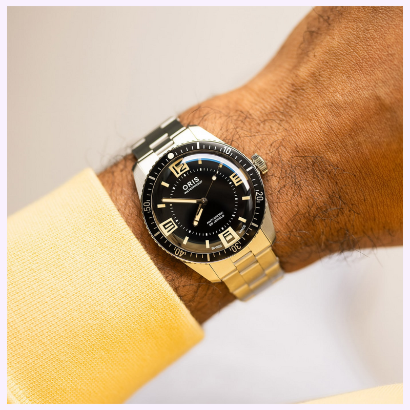 Oris Divers Sixty-Five 60th Anniversary Edition worn on the wrist showing its 40mm case, black dial and stainless steel bracelet