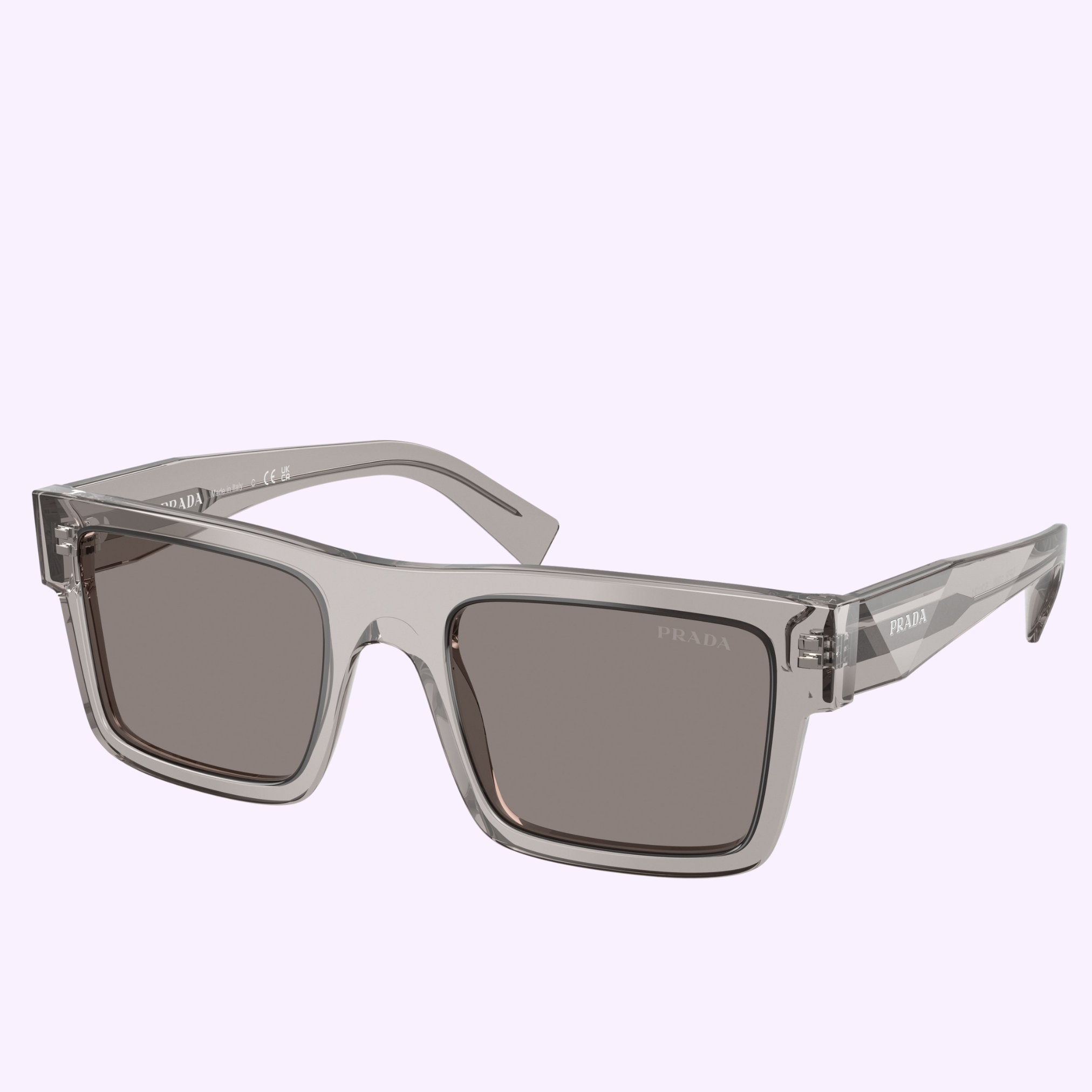 The PRADA Sunglasses 0PR 19WS 10J80Q52 feature clear rectangular gray frames with dark lenses and subtle Prada logos on the temple and lens, set against a light lavender background—signature style from Prada Sunglasses.