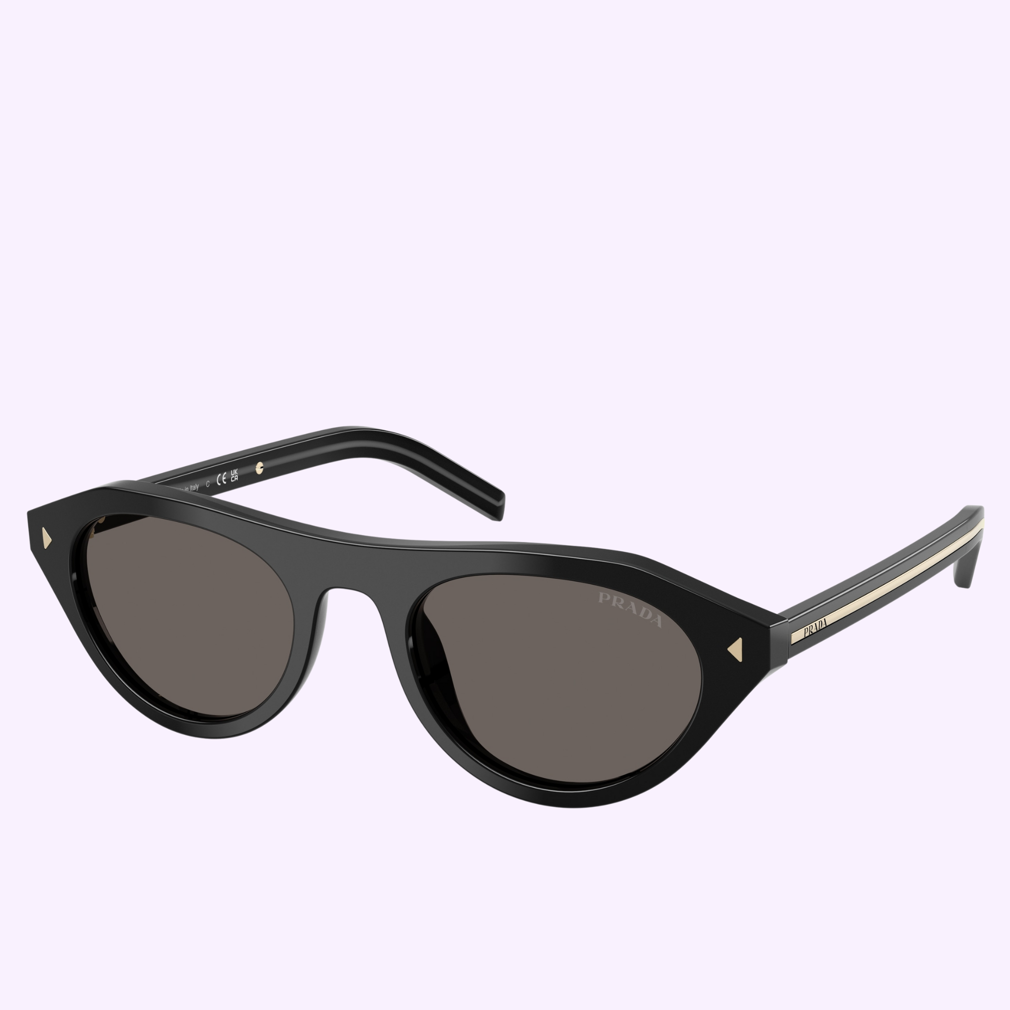 The PRADA Sunglasses 0PR B15S 16K73151 feature black cat-eye frames, dark lenses, and gold temple accents by Prada Sunglasses, displayed on a light purple background for a blend of classic style and sporty flair.