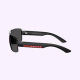 PRADA Sunglasses 0PS B52S 1AB06F65 by Prada Sunglasses feature black frames, dark lenses, a red stripe, and white Prada logo on the temple, displayed side-on against a light purple background.