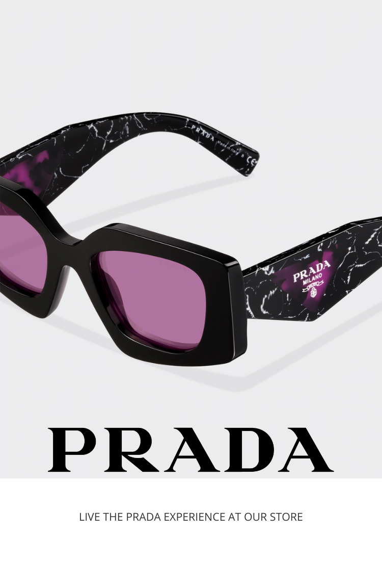 Close-up of black Prada sunglasses with purple lenses and marble-patterned arms, featuring the Prada logo. The text below reads “PRADA” and “LIVE THE PRADA EXPERIENCE AT OUR STORE.”.