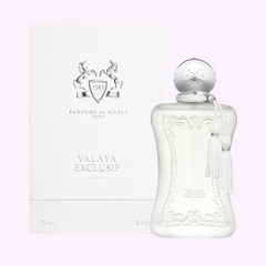 The Parfums de Marly Valaya Exclusif EDP 2.5 oz for women (UPC 3700578505767) features a sleek white bottle with silver accents and tassel beside its matching box—ideal for fans of floral woody scents from Parfums De Marly Perfumes.