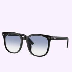 Light blue Persol Sunglasses 0PO3345S 96/56 54 with sleek black frames and blue gradient lenses, featuring the Persol logo on the top corner of the right lens and temple. Inspired by classic eyewear styles, this design stands out with its fresh light blue hues set against a soft pastel purple background.